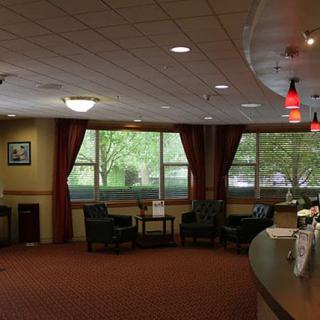 A cozy lobby with a seating area and large windows.