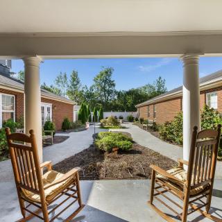 Two rocking chairs overlook a beautifully landscaped courtyard.