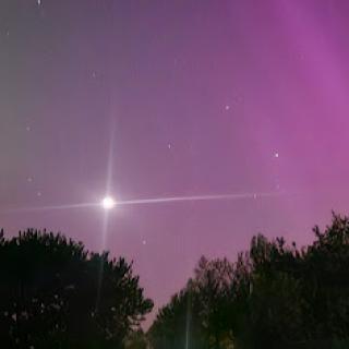 A mesmerizing display of the night sky featuring vibrant auroras and a bright celestial object.