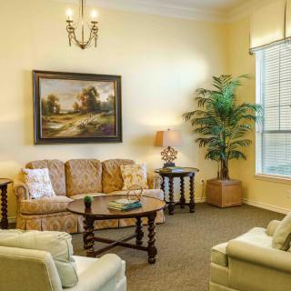 A cozy living room with a sofa, coffee table, and a painting on the wall.