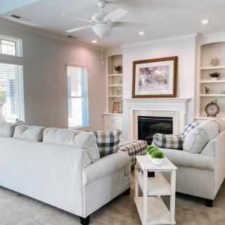 A bright and modern living room with cozy sofas and a fireplace.