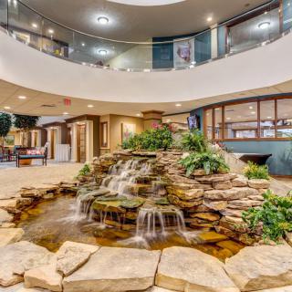 A modern lobby featuring an indoor waterfall and natural stone decor.