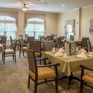 Elegant dining area with neatly arranged tables and chairs, highlighted by natural light from large windows.