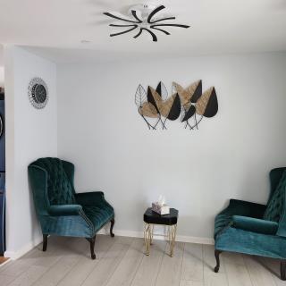 A modern living room with teal chairs and contemporary wall art.
