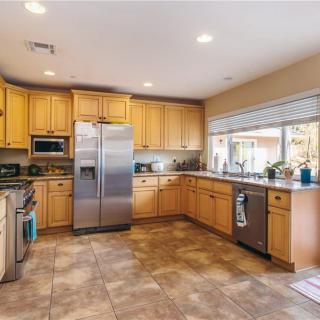 A modern, spacious kitchen with wooden cabinets and stainless steel appliances.