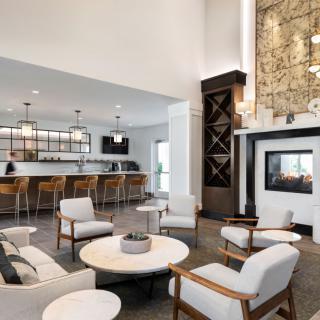 A modern and spacious interior living area with a cozy seating arrangement and bar.