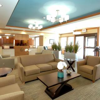 A spacious and well-decorated lobby with comfortable seating, warm lighting, and decorative plants.