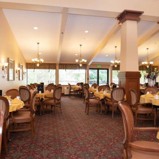 A spacious restaurant dining area with elegant wooden furniture and warm lighting.