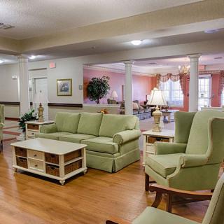 A cozy living room featuring green upholstered furniture and a wooden coffee table.