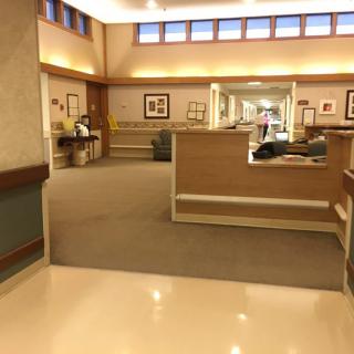 A spacious hospital hallway with seating areas and soft lighting.