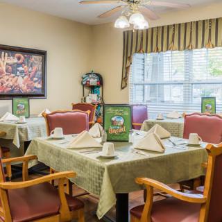 A cozy dining room with tables set for guests, featuring menus and neatly folded napkins.