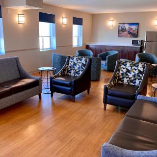A cozy lounge area featuring various seating options, including sofas and armchairs.