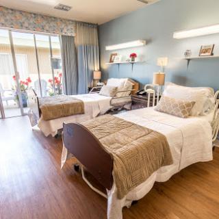 A well-lit and inviting patient room featuring two beds and a serene environment.