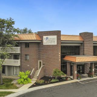 A modern commercial building with brick exterior and a landscaped entrance.