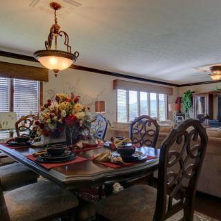 A cozy dining room with a decorated table and chandelier lighting.