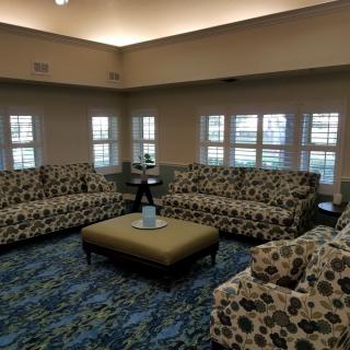 A cozy living room with patterned sofas and a central ottoman.
