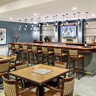 A modern bar and restaurant interior with seating and a television.