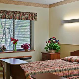 A cozy bedroom with floral decorations and a window view.