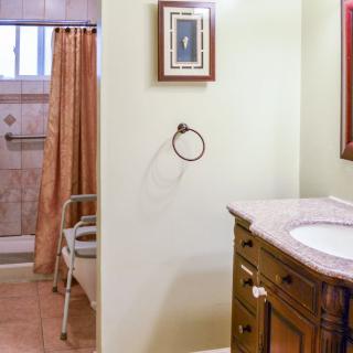 A cozy bathroom with a shower area, sink, and wooden vanity.