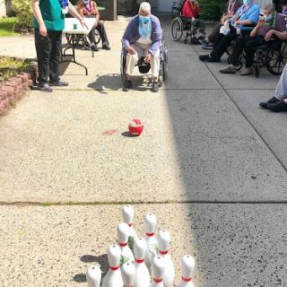 Residents enjoying a fun bowling game outside.