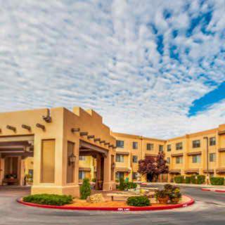 A picturesque hotel building with unique architectural design set against a vibrant sky backdrop.
