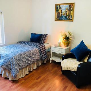 A cozy bedroom with a single bed, armchair, and decorative elements.