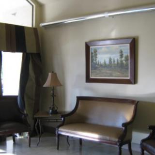 A cozy living room with a sofa, lamp, and wall painting.
