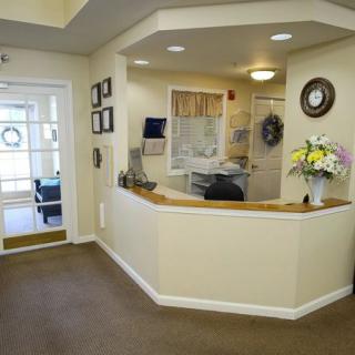 A welcoming reception area with a desk, flowers, and comfortable lighting.