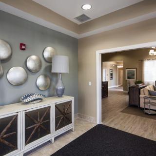 A stylish lobby area featuring modern decor with wall art, a lamp, and comfortable seating.