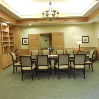 A modern meeting room with a large conference table and chairs.