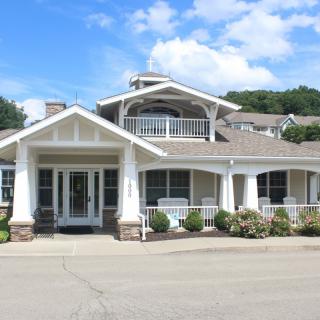 A modern residential house with a porch and well-maintained landscaping.