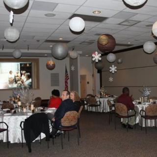 A decorated indoor event space with tables set up and a projected image on the wall.