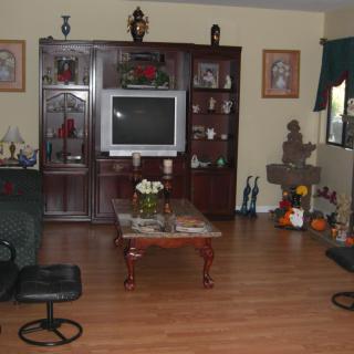 A cozy living room with a television, coffee table, and various decorations.