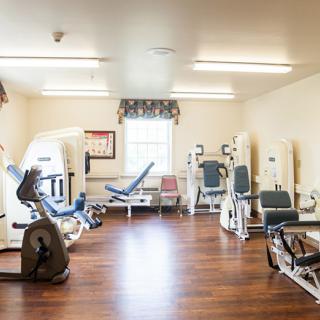 A well-equipped gym room featuring various exercise machines.
