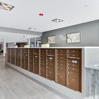 A modern apartment lobby with a row of mailboxes.