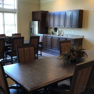 A spacious dining area with a table and chairs adjacent to a kitchen setup.