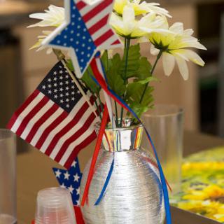 A festive centerpiece featuring flowers and American flags, perfect for patriotic celebrations.