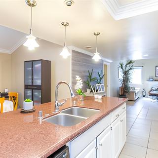 Modern kitchen with an island counter and pendant lights, featuring bright and open space.