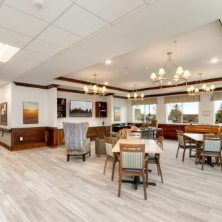 A bright, modern dining area with elegant chandeliers and wooden flooring.