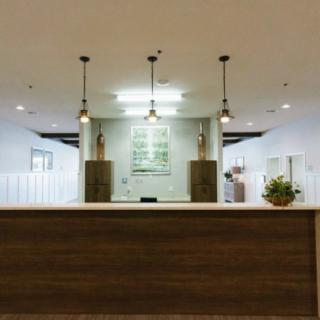 Modern office reception area with minimalist design and pendant lighting.