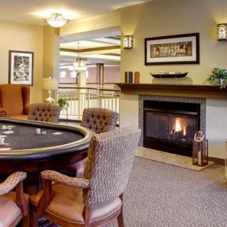 A cozy living room featuring a poker table and fireplace.