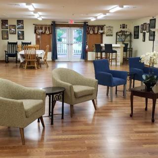 A well-arranged sitting area with comfortable chairs and tables on a wooden floor.