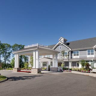 A well-maintained building exterior with a grand entrance and surrounding landscaped area.
