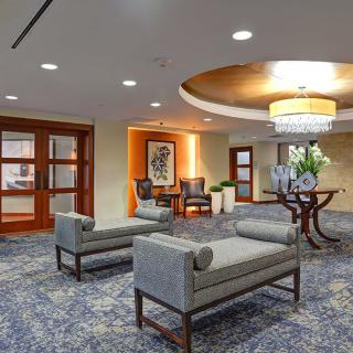 A stylish hotel lobby featuring modern seating and a chandelier.