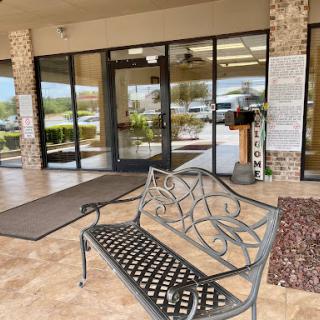 A welcoming entrance area featuring a decorative bench and glass doors.