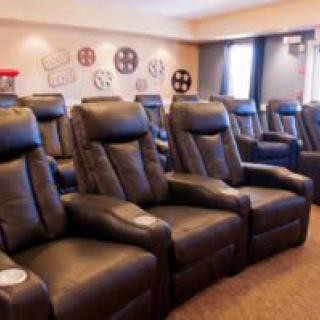 A cozy home theater setup with rows of comfortable recliner seats.