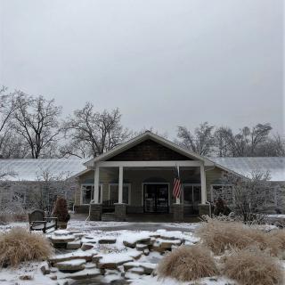 A house surrounded by a snowy landscape under an overcast sky.