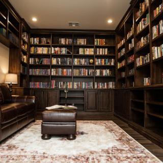 A warm and inviting home library filled with books and a comfortable reading area.