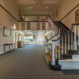 A spacious, elegant lobby with a staircase leading to an upper level.