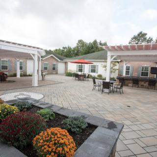 A peaceful courtyard with seating areas and pergolas surrounded by well-maintained landscaping.